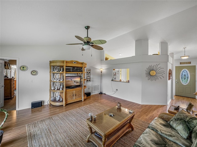 living room featuring vaulted ceiling, ceiling fan, and hardwood / wood-style flooring