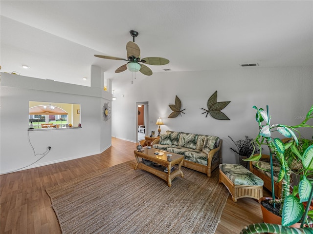 living room with wood-type flooring, vaulted ceiling, and ceiling fan