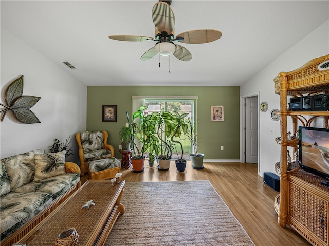 living room with ceiling fan and light hardwood / wood-style flooring