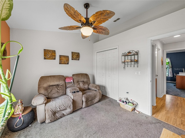 living room with wood-type flooring and ceiling fan