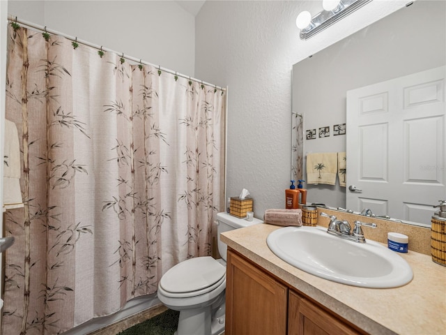 bathroom with curtained shower, vanity, and toilet