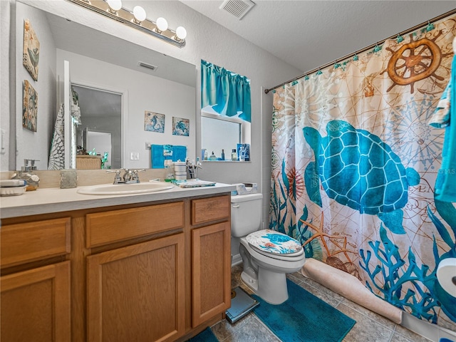 bathroom featuring a textured ceiling, vanity, toilet, and tile patterned floors