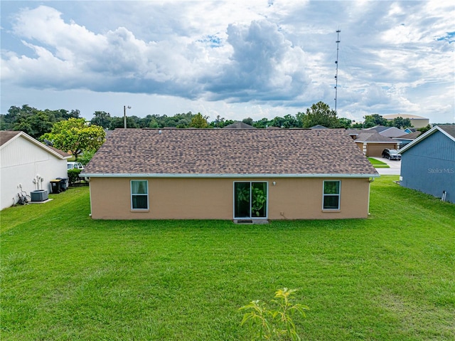 rear view of house featuring a yard and central AC