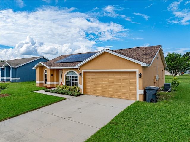 ranch-style home featuring a front yard, a garage, solar panels, and central AC