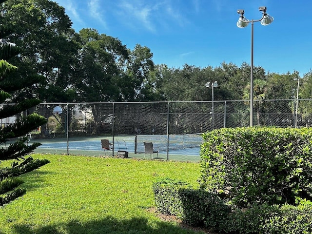 view of sport court with a lawn