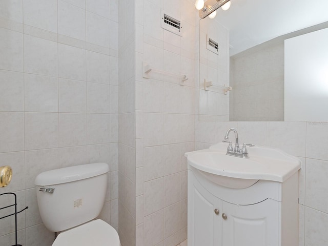 bathroom featuring tile walls, vanity, and toilet