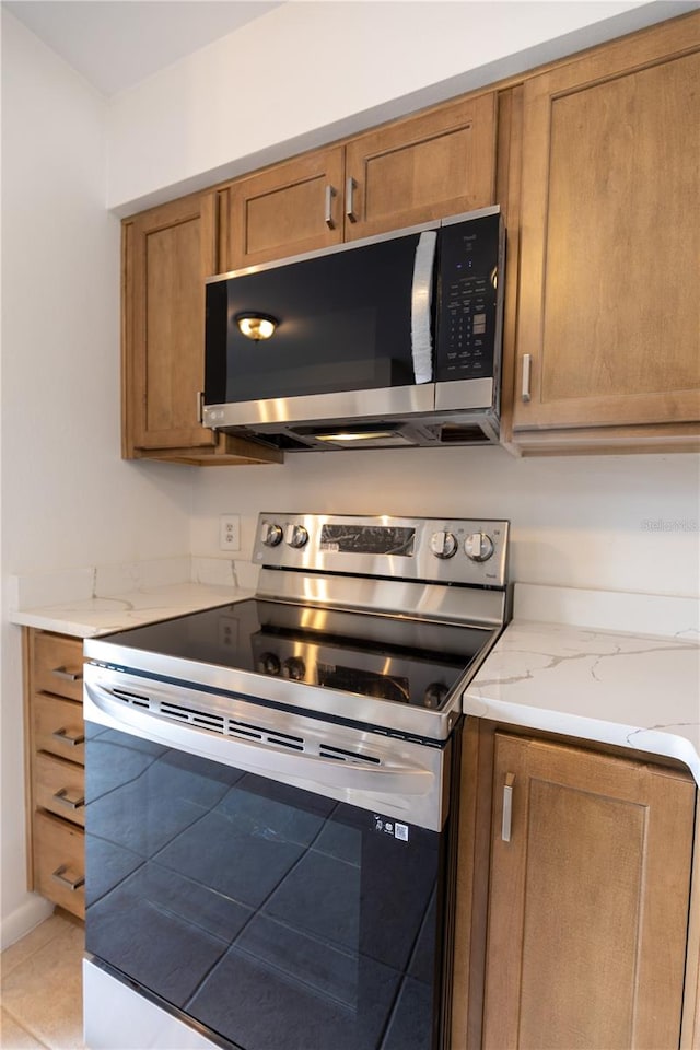 kitchen featuring light tile patterned floors and stainless steel appliances