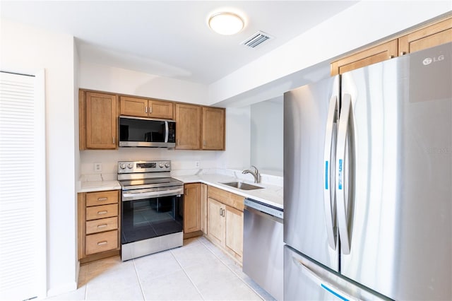 kitchen featuring appliances with stainless steel finishes, sink, and light tile patterned floors