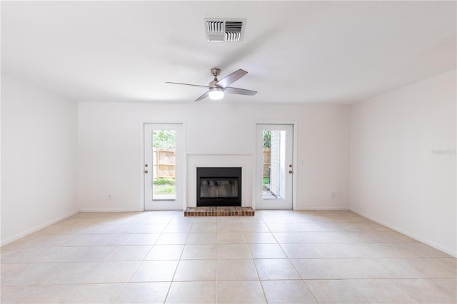 unfurnished living room with light tile patterned floors, ceiling fan, and a brick fireplace