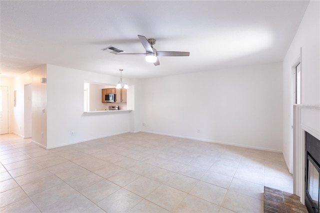 unfurnished living room with light tile patterned flooring and ceiling fan with notable chandelier