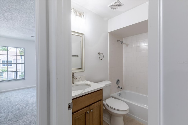 full bathroom with vanity, a textured ceiling, tiled shower / bath combo, tile patterned flooring, and toilet