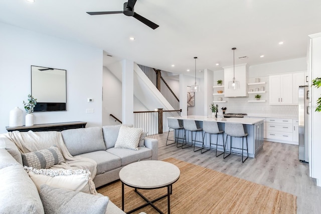 living room with light wood-type flooring and ceiling fan