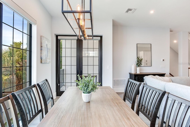 dining room with light wood-type flooring and a chandelier