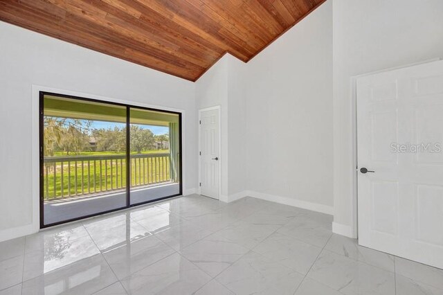 empty room with wood ceiling and high vaulted ceiling