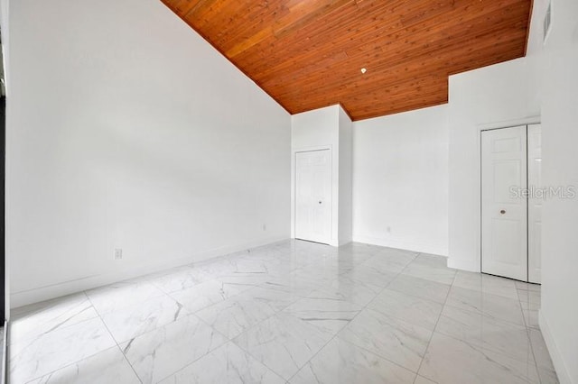 unfurnished room with wood ceiling and high vaulted ceiling