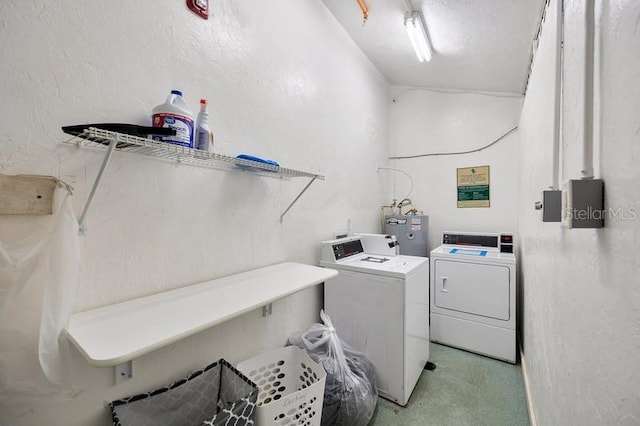 laundry room with water heater and separate washer and dryer