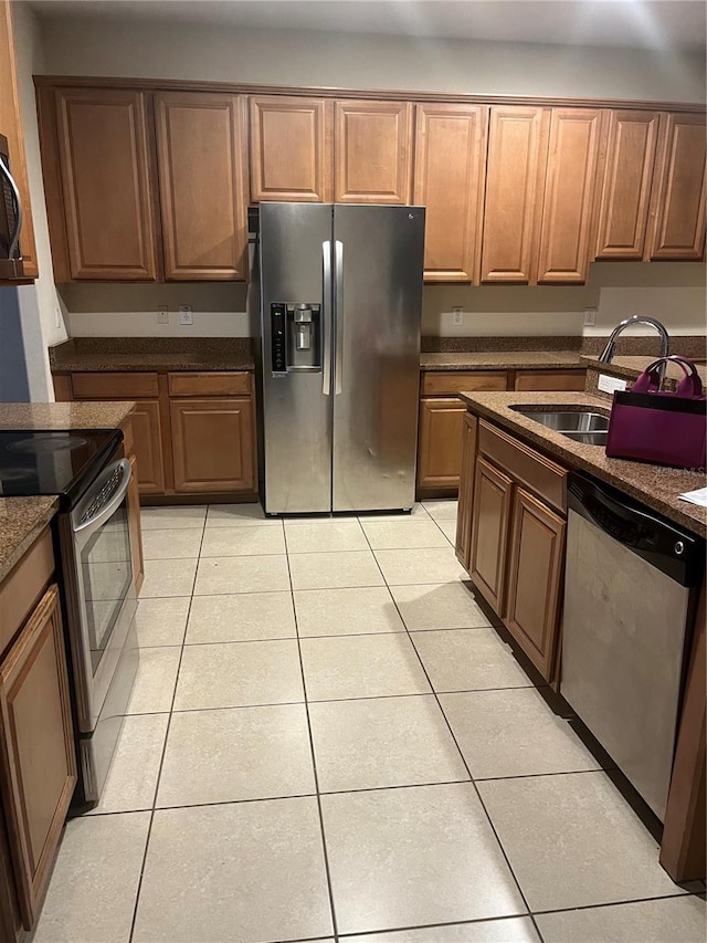 kitchen featuring appliances with stainless steel finishes, light tile patterned floors, and sink