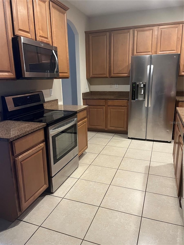 kitchen with stainless steel appliances and light tile patterned flooring