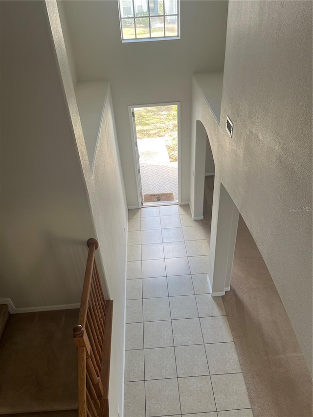 foyer entrance featuring a wealth of natural light, a high ceiling, and light tile patterned floors