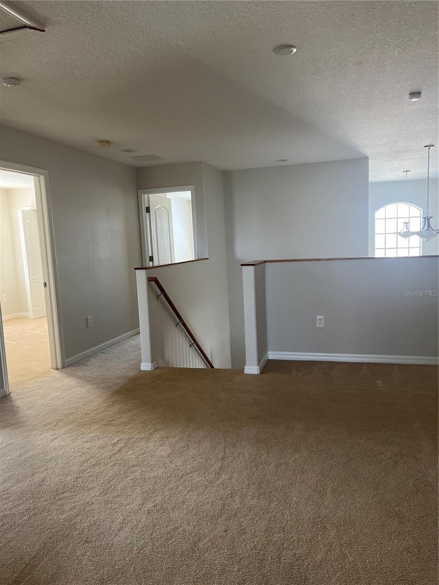 carpeted spare room with a textured ceiling