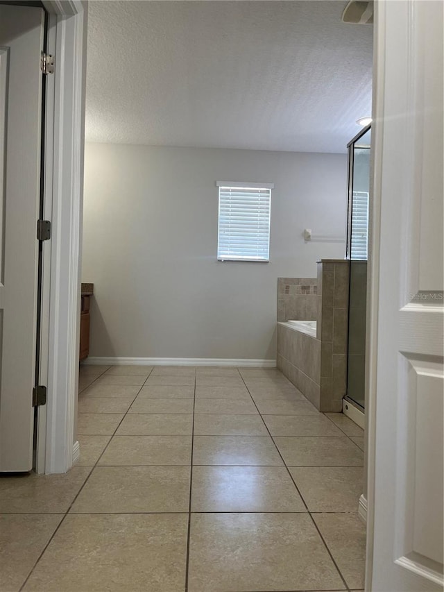 bathroom featuring plus walk in shower, tile patterned floors, a textured ceiling, and vanity