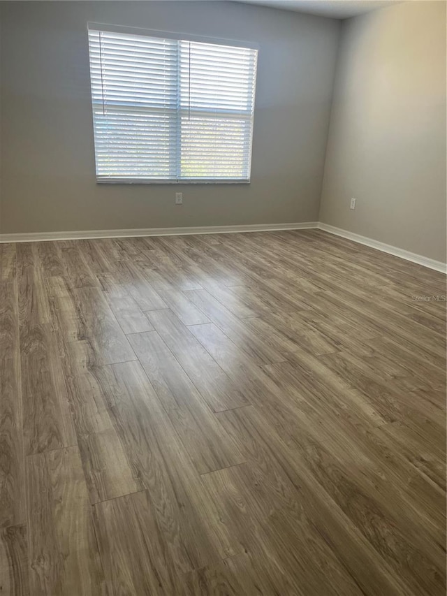 unfurnished room with hardwood / wood-style flooring