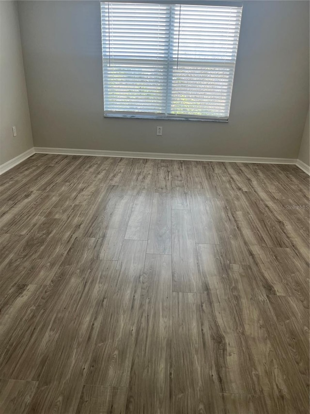 unfurnished room with dark hardwood / wood-style flooring