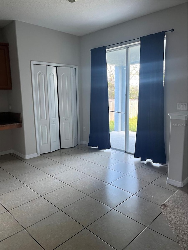 interior space featuring a textured ceiling and light tile patterned flooring