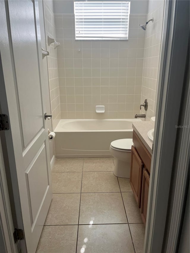 full bathroom featuring vanity, tiled shower / bath, tile patterned floors, and toilet