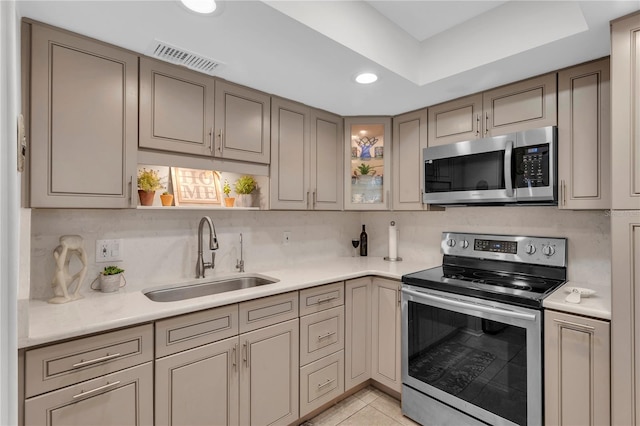 kitchen with light tile patterned flooring, backsplash, stainless steel appliances, and sink