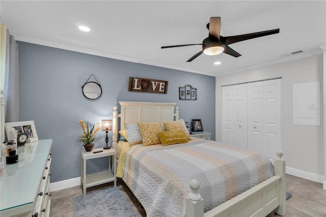 bedroom with light tile patterned floors, a closet, ceiling fan, and crown molding