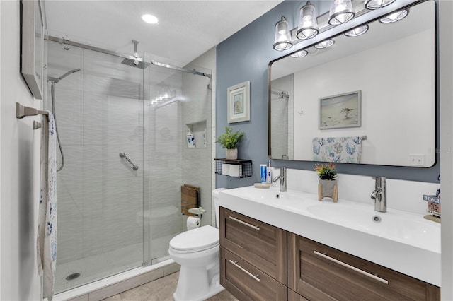 bathroom with tile patterned flooring, a shower with door, vanity, and toilet