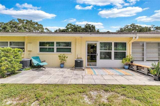 rear view of property featuring central AC unit and a patio