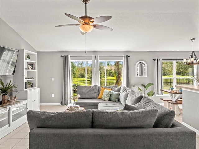 living room with ceiling fan with notable chandelier, light tile patterned floors, a textured ceiling, and built in shelves