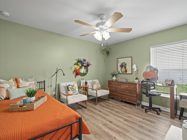 bedroom with ceiling fan and light hardwood / wood-style floors