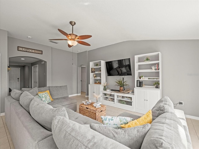 tiled living room featuring ceiling fan, lofted ceiling, and built in shelves