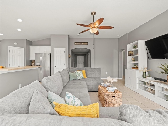 tiled living room featuring ceiling fan, lofted ceiling, and built in shelves