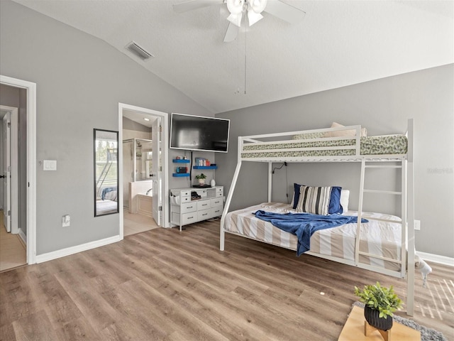 bedroom with a textured ceiling, vaulted ceiling, ceiling fan, wood-type flooring, and connected bathroom