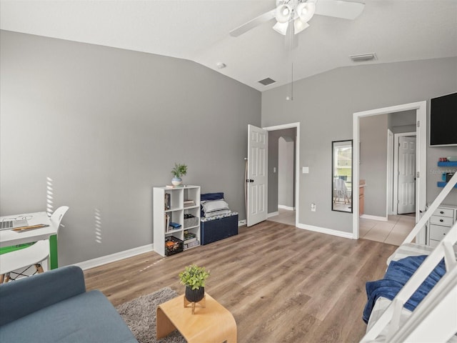 living room featuring ceiling fan, light hardwood / wood-style floors, and vaulted ceiling