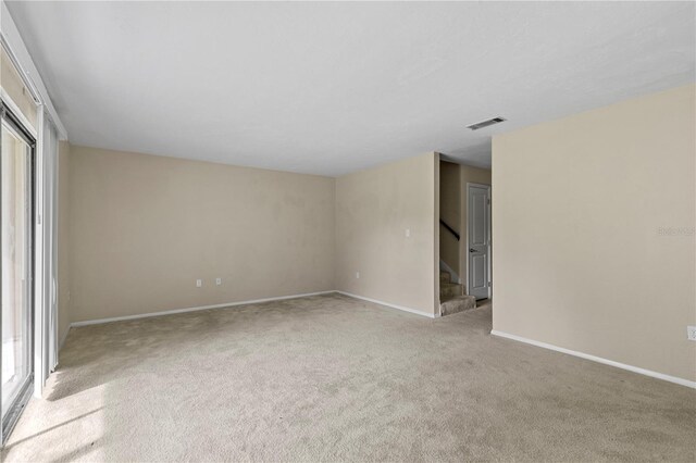 507 NW 39th Rd Unit 318, Gainesville, FL 32607 - carpeted spare room featuring stairway and baseboards