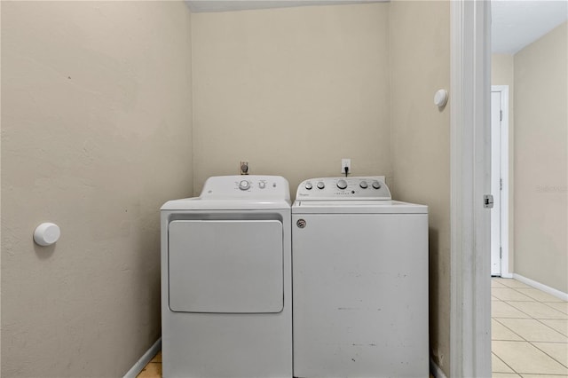 507 NW 39th Rd Unit 318, Gainesville, FL 32607 - washroom with washing machine and dryer, light tile patterned floors, and baseboards