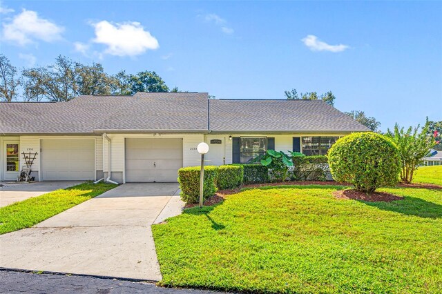 ranch-style home featuring a garage and a front lawn