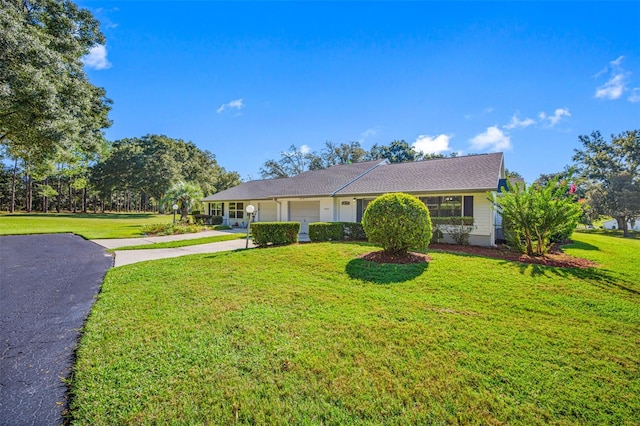 single story home featuring a front lawn and a garage