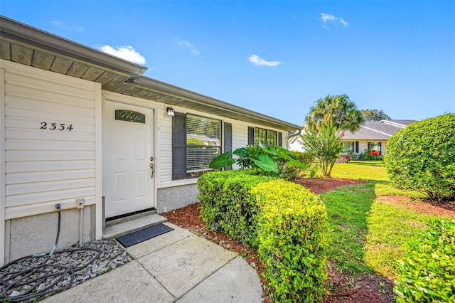 entrance to property featuring a yard