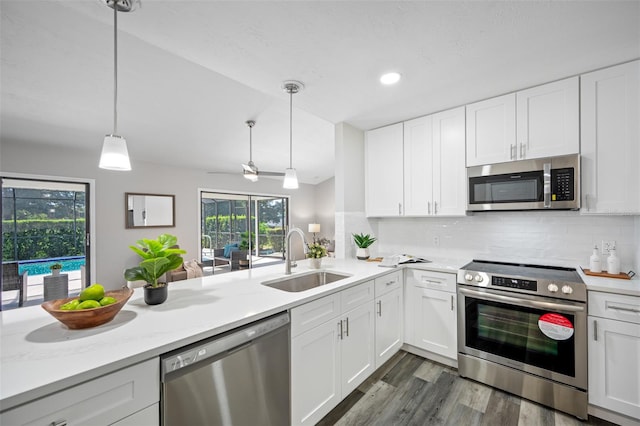 kitchen featuring sink, appliances with stainless steel finishes, decorative light fixtures, and white cabinetry