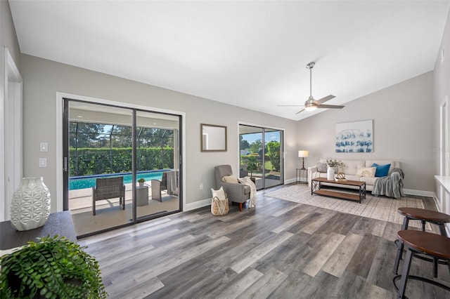 living room featuring ceiling fan, hardwood / wood-style flooring, and vaulted ceiling