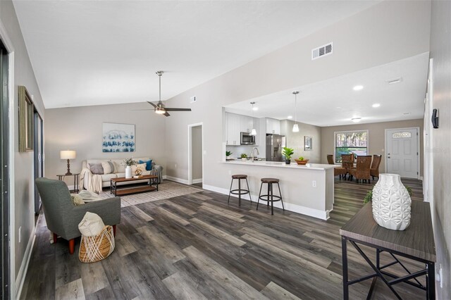 living room with sink, dark wood-type flooring, vaulted ceiling, and ceiling fan