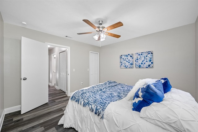 bedroom with dark hardwood / wood-style flooring and ceiling fan