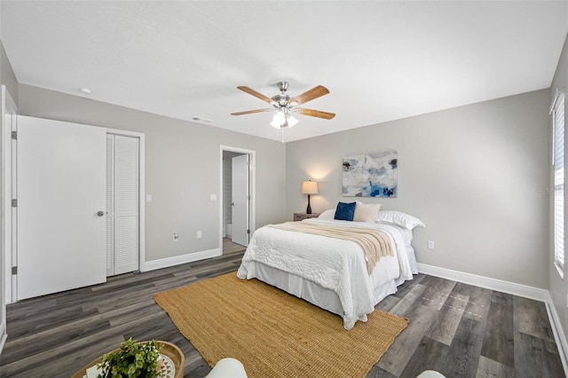 bedroom featuring dark wood-type flooring, ceiling fan, and a closet