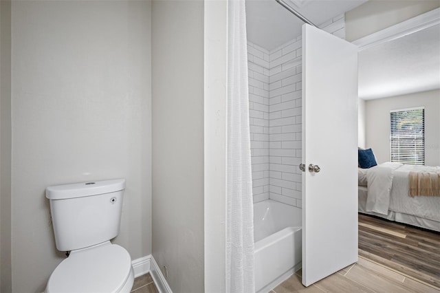 bathroom featuring toilet, hardwood / wood-style flooring, and shower / tub combo